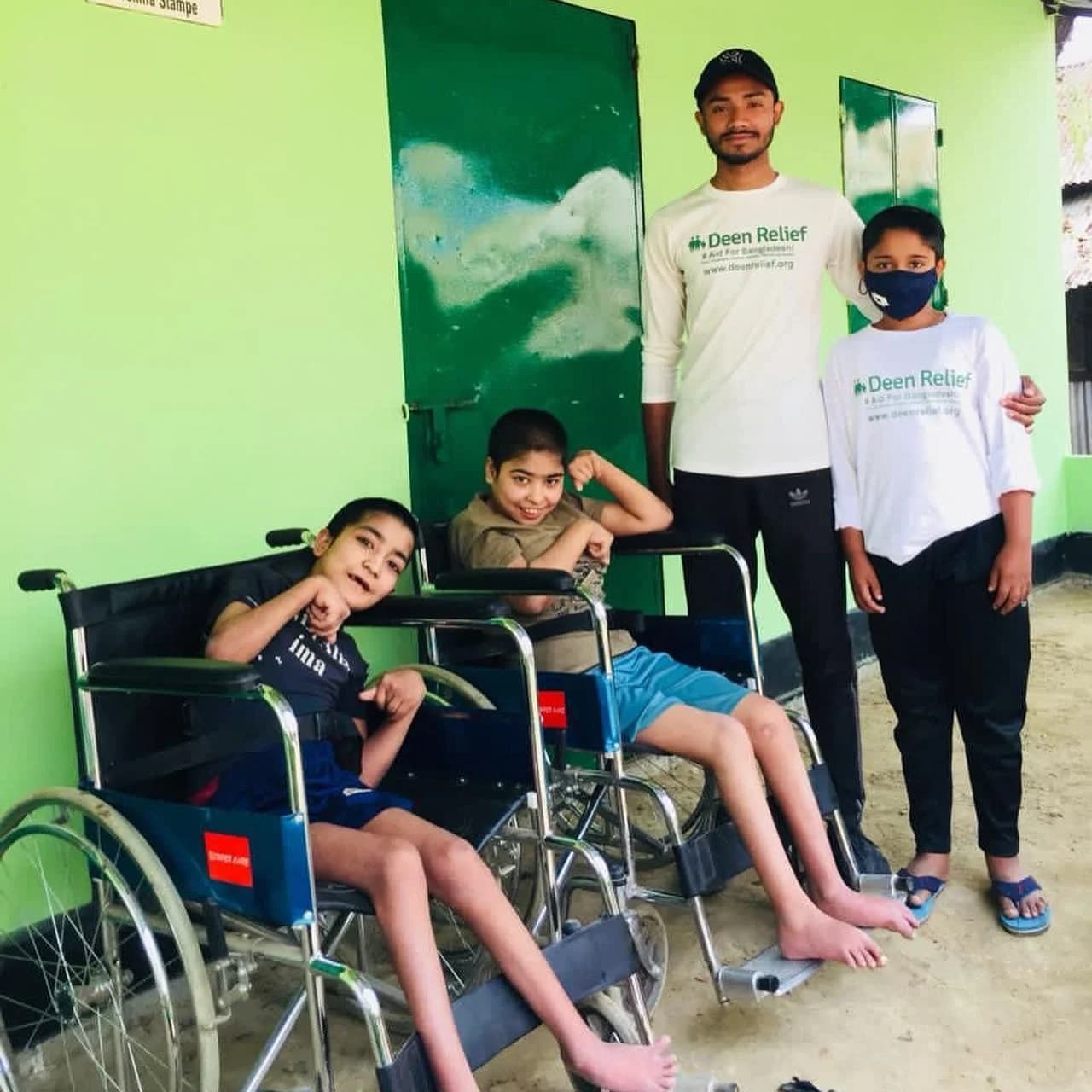 A Deen Relief field worker with three children, two of whom use wheelchairs, at a Bangladesh community centre