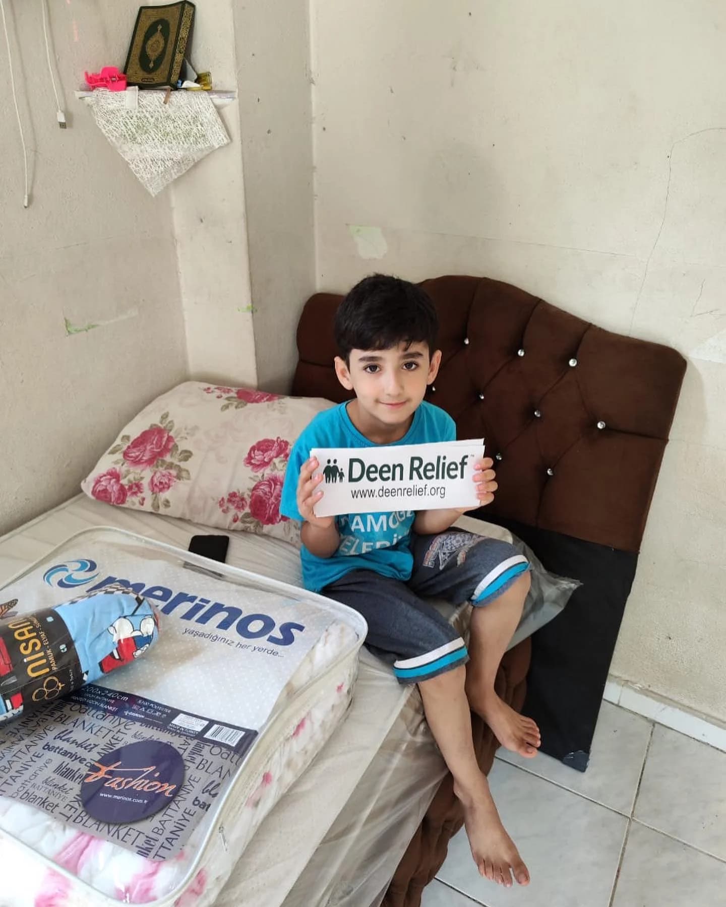 A child receiving bedding supplies in his room at the family housing programme in Adana