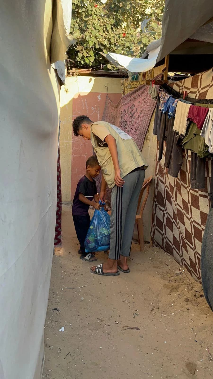 Deen Relief worker delivering aid to a child in a Gaza displacement camp