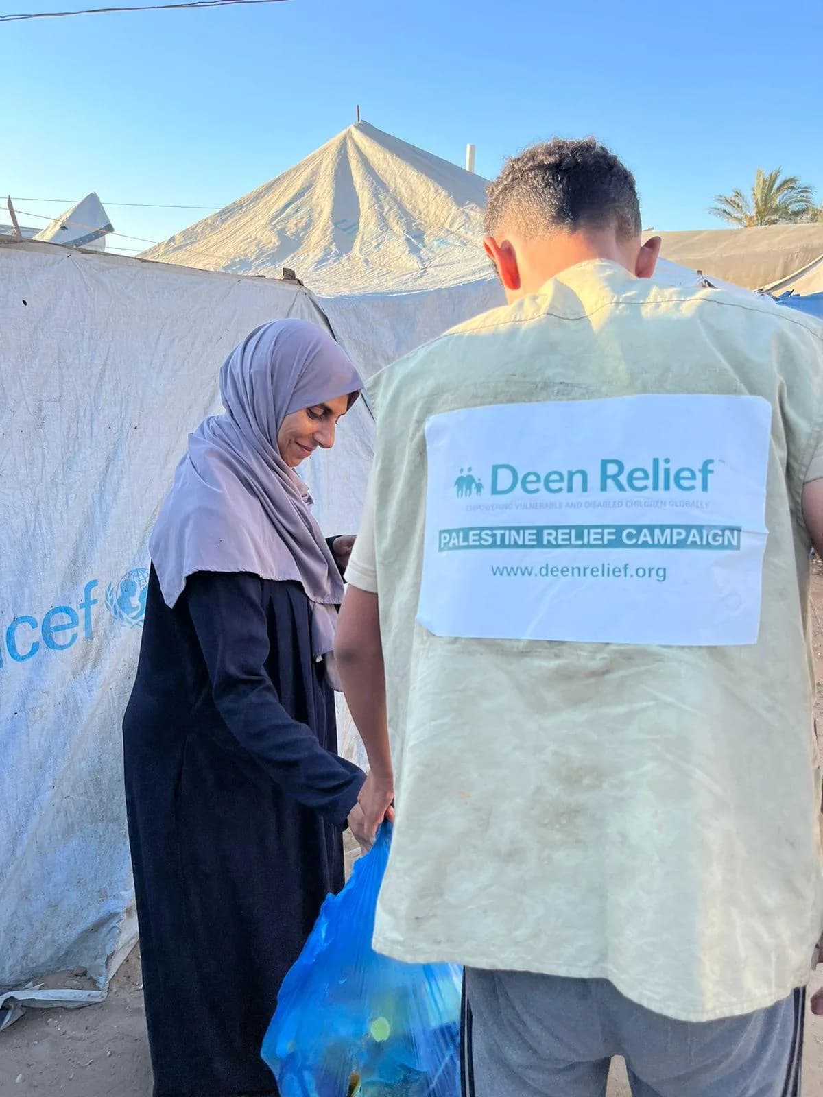 Deen Relief Palestine Relief Campaign worker distributing aid to a woman