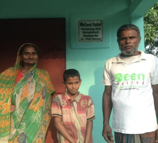 A family standing in front of their Deen Relief housing project in Bangladesh