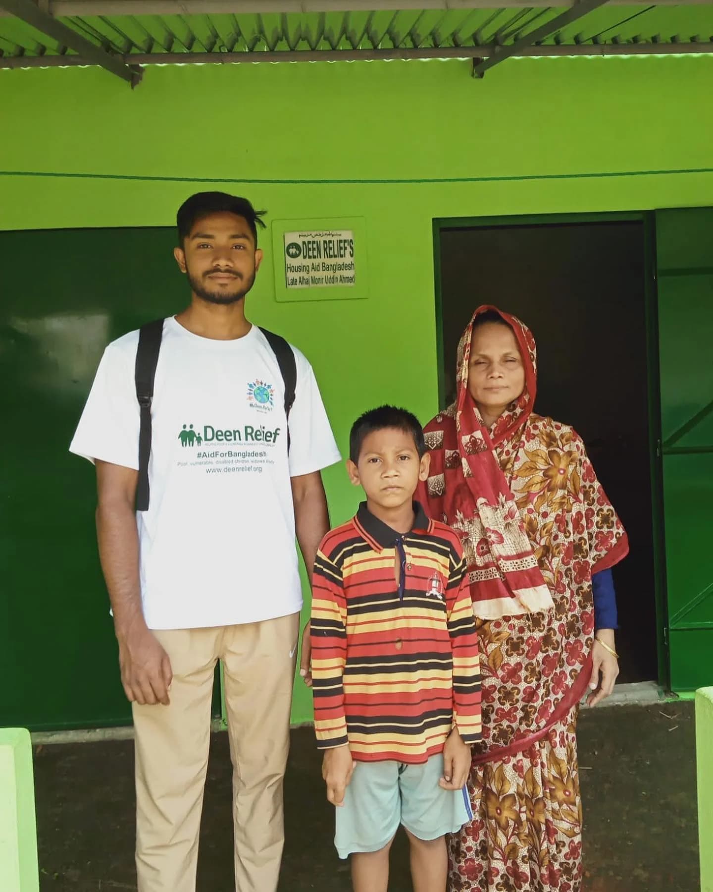 Deen Relief team member with a young boy and his grandmother at the Bangladesh community housing aid centre