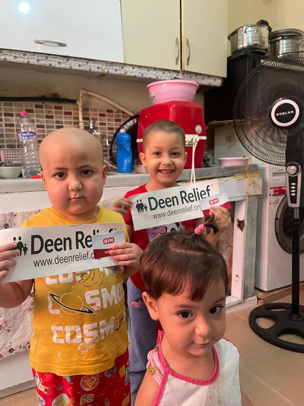 Children at Deen Relief's care centre holding Deen Relief signs