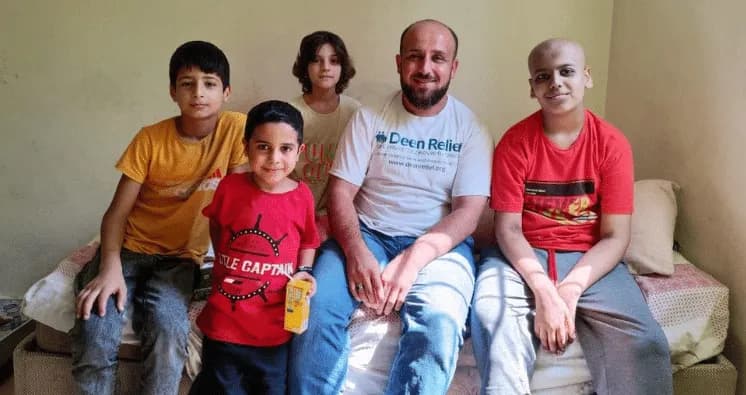 Deen Relief team member with children at Gulucuk Evi cancer care centre