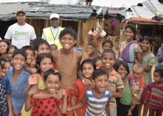 Deen Relief team with a large group of smiling children in Bangladesh