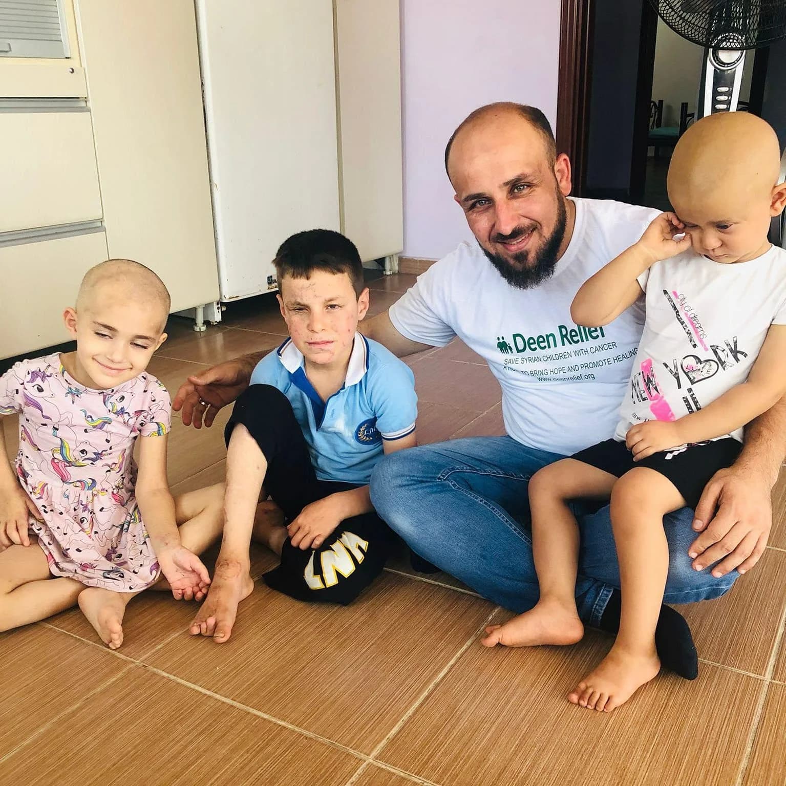 Deen Relief team member with three Syrian children supported by the cancer-care programme